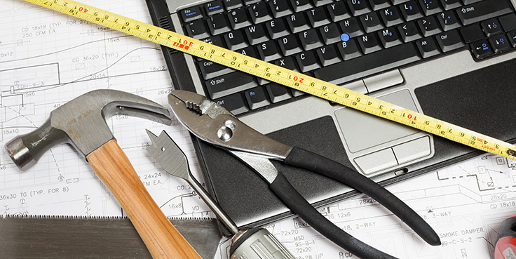 Laptop with hammer and plier tool next to it